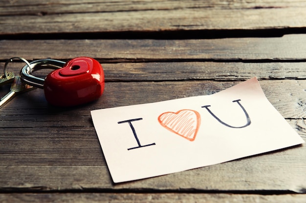 Mensaje escrito con corazón decorativo en la mesa de madera de cerca