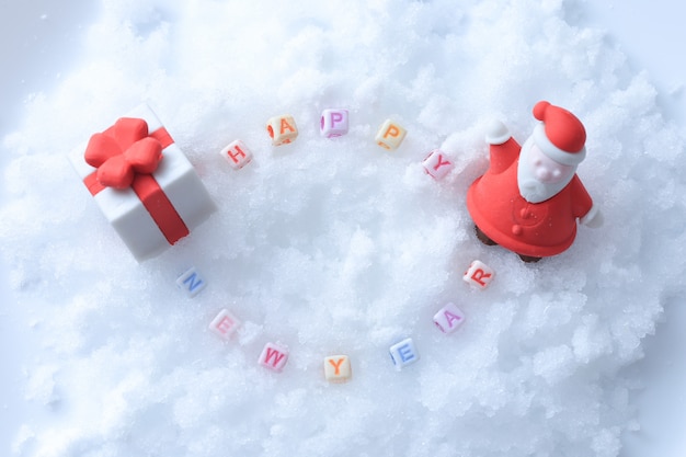 Mensaje de feliz año nuevo hecho con cubos de letras sobre nieve