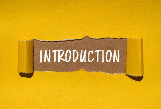 Mensaje de introducción escrito en papel amarillo rasgado con fondo marrón Símbolo de introducción conceptual Copiar espacio