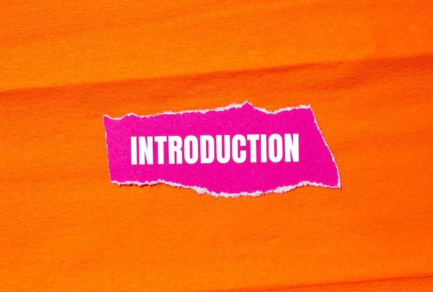 Mensaje de introducción escrito en papel rosado rasgado con fondo naranja Símbolo de introducción conceptual Copiar espacio