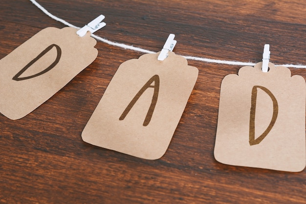 Mensaje de papá escrito en las etiquetas que cuelgan en clothespins sobre fondo de madera