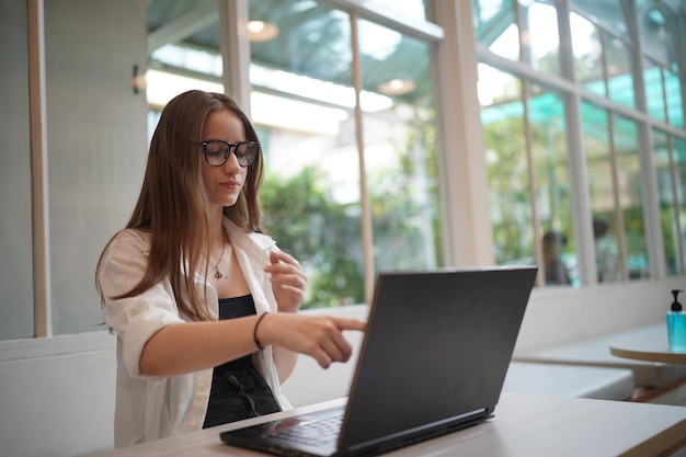 Mensaje de texto de estudiante en la computadora portátil en el café