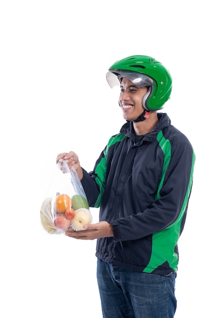 Mensajero con casco y chaqueta uniforme sosteniendo alimentos aislado sobre fondo blanco.