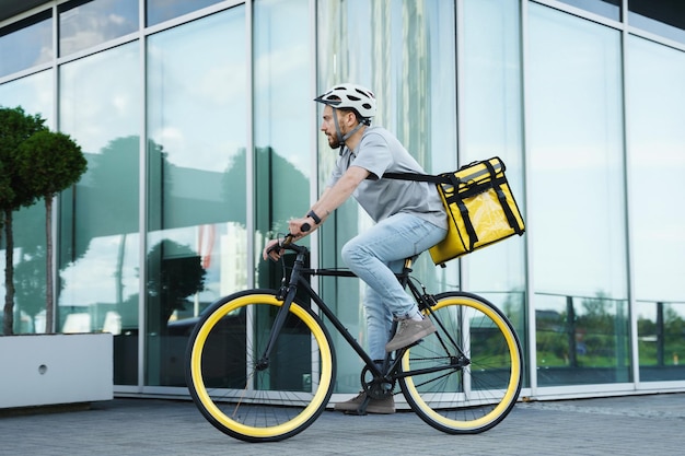 Mensajero de entrega urgente en bicicleta con bolsa aislada