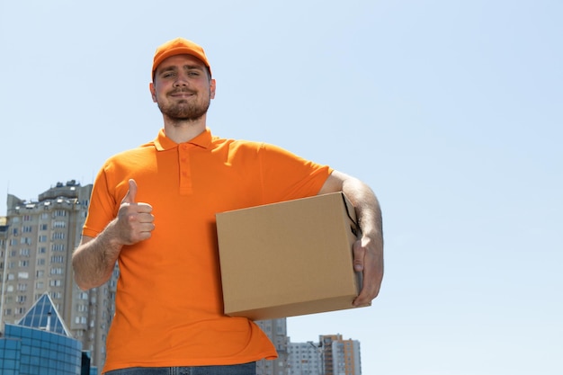 Un mensajero feliz cerca de un auto con cajas.