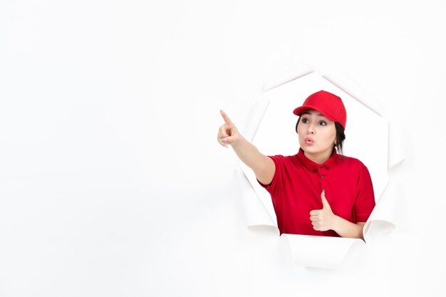 Mensajero femenino en uniforme rojo apuntando arriba en blanco