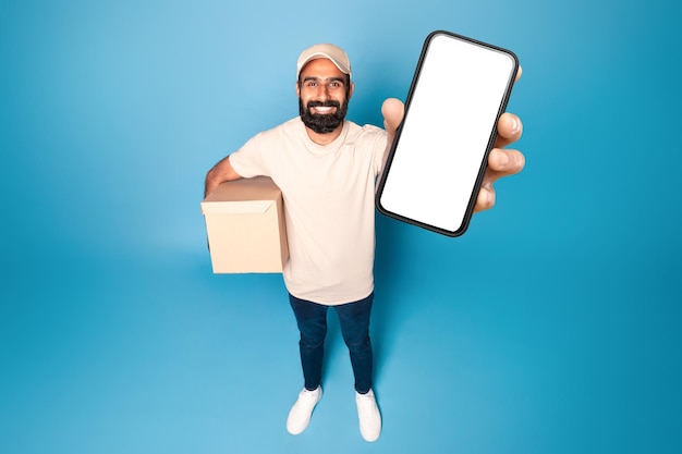 Mensajero indio mostrando un teléfono celular con pantalla en blanco y sosteniendo publicidad en cajas de cartón