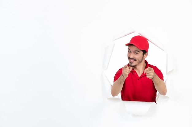 Foto mensajero joven amable en uniforme rojo sobre blanco