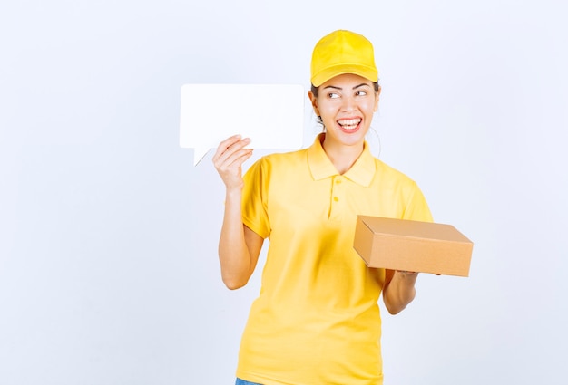 Mensajero mujer en uniforme amarillo ofreciendo el pedido al cliente y presentando el certificado de autenticidad.