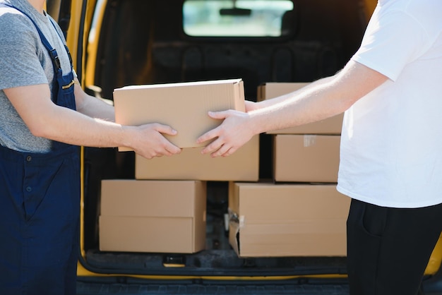 El mensajero trajo la entrega de la caja al cliente Empleado de servicio de mensajería en uniforme