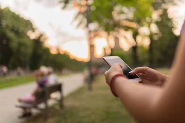 Mensajes de mensajes de texto femeninos en el parque