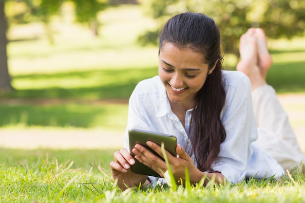 Mensajes de texto de mujer mientras se relaja en el parque