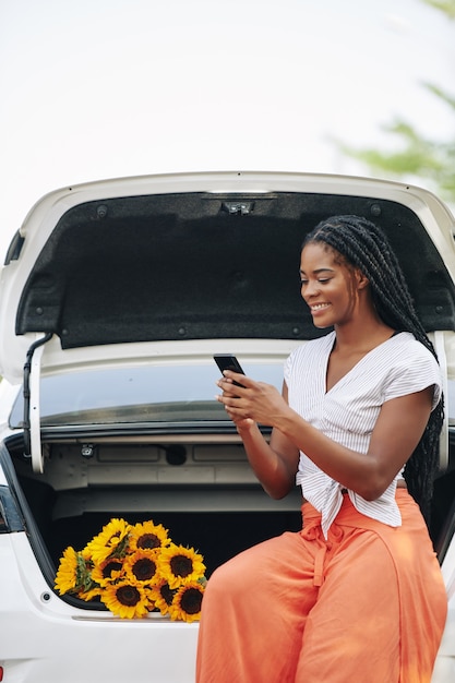 Mensajes de texto mujer sentada en el maletero del coche
