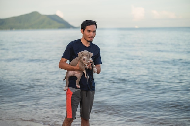 Mensch und Hund reisen am Meeresstrand