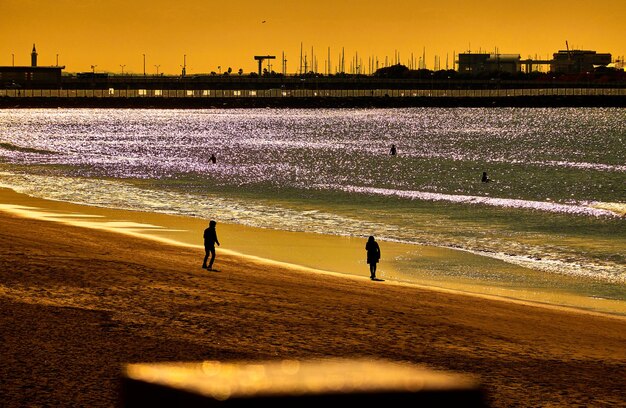 Foto menschen am strand am meer gegen den himmel bei sonnenaufgang