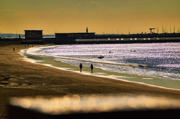 Foto menschen am strand gegen den himmel bei sonnenaufgang