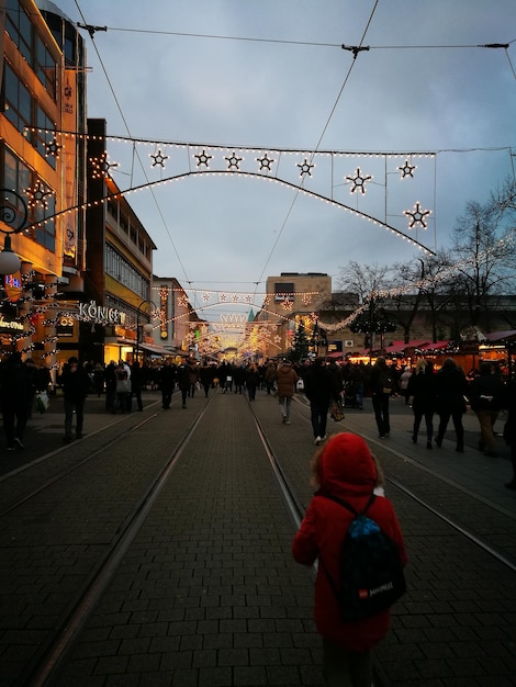 Menschen auf der Straße in der Stadt gegen den Himmel