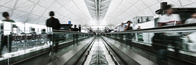 Menschen auf einem Fahrsteig in einem Passagierterminal am Flughafen