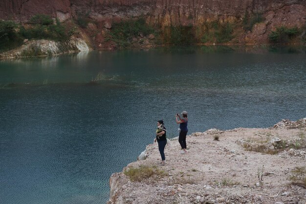 Menschen auf einem Felsen am See