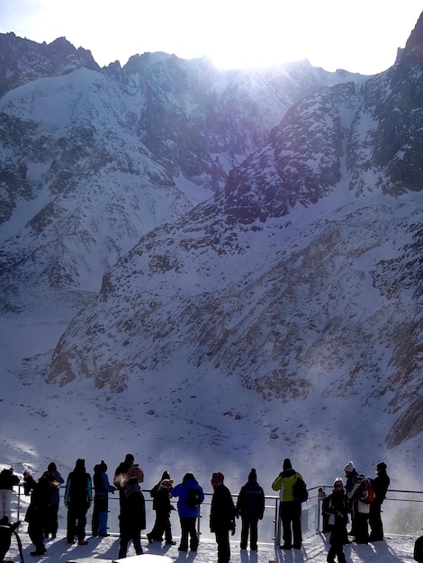 Foto menschen auf einer brücke gegen schneebedeckte berge