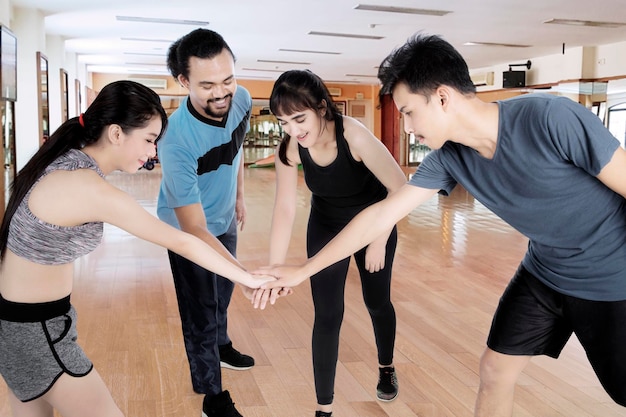 Menschen der Vielfalt reichen sich im Fitnesscenter die Hände