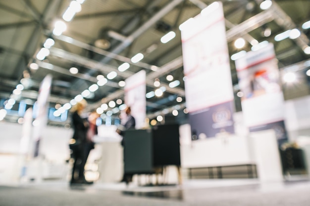 Foto menschen, die auf einem messestand stehen, generischer hintergrund mit einem angewendeten unschärfeeffekt