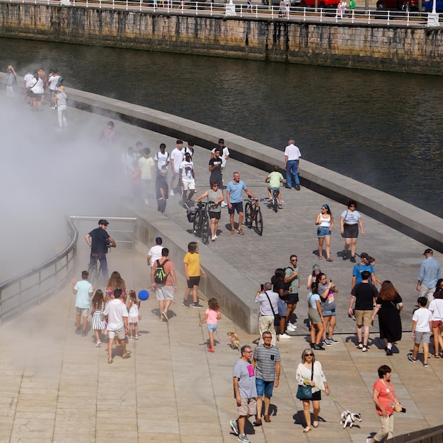 Menschen, die auf einer Promenade laufen und aus denen Rauch austritt