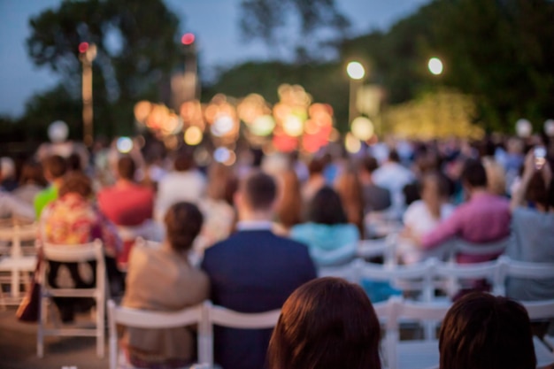 Menschen, die das Konzert der klassischen Band bei Tageslicht im Freien beobachten, verschwommenes Foto