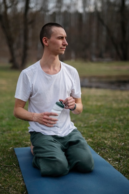 Foto menschen, die draußen yoga praktizieren