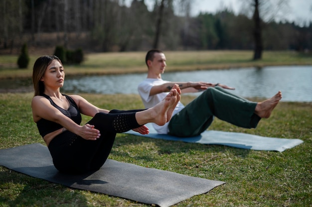 Menschen, die draußen Yoga praktizieren