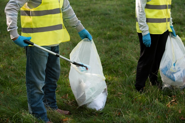 Foto menschen, die gemeinnützige arbeit leisten, indem sie müll in der natur sammeln