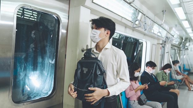 Menschen, die Gesichtsmasken in einem überfüllten öffentlichen U-Bahnzug tragen