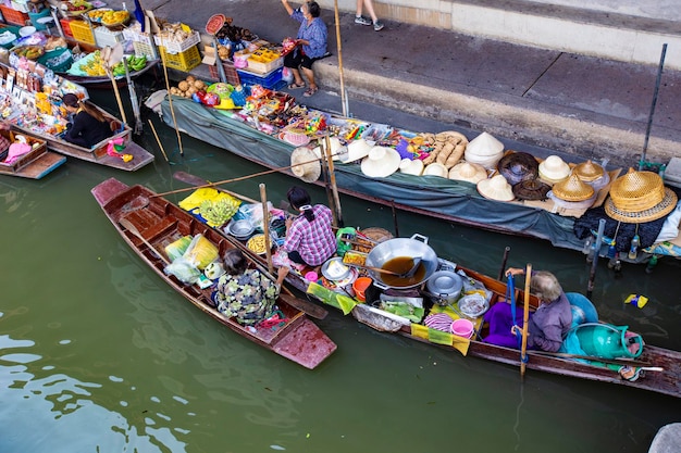 Menschen, die Lebensmittel und Gemüse auf dem Damnoen Saduak Floating Market unweit der Stadt Bangkok, Thail, verkaufen