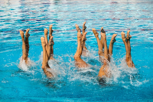 Foto menschen, die synchrones schwimmen im pool durchführen