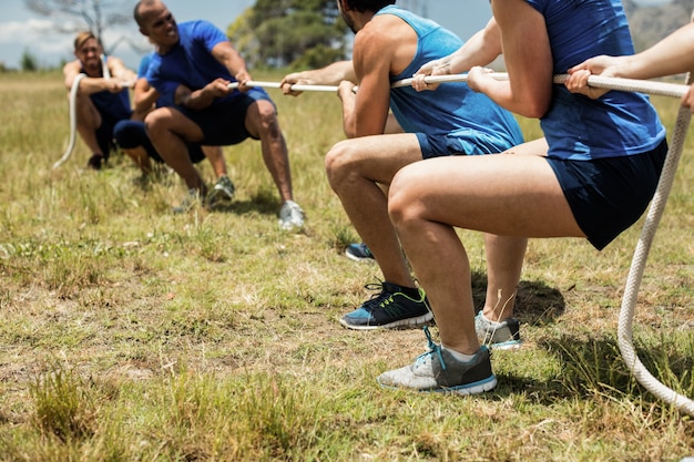 Foto menschen, die tauziehen während des hindernis-trainingskurses spielen