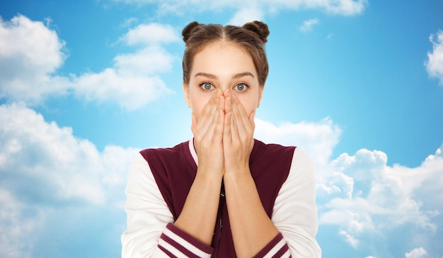 Menschen, Emotionen, Ausdruck und Teenager-Konzept - verängstigtes oder verwirrtes Teenager-Mädchen über blauem Himmel und Wolkenhintergrund