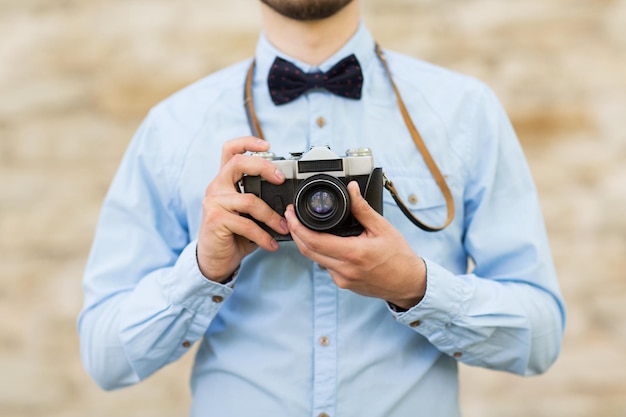 Menschen, Fotografie, Technologie, Freizeit und Lifestyle - Nahaufnahme eines jungen Hipster-Mannes mit Retro-Vintage-Filmkamera auf der Straße der Stadt