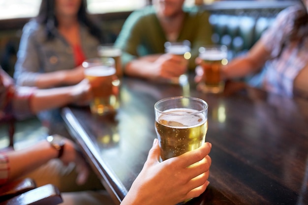 Menschen-, Freizeit- und Getränkekonzept - Freunde trinken Bier und in der Bar oder Kneipe