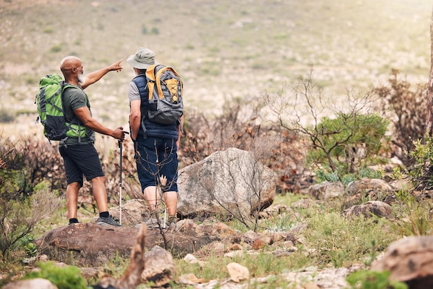 Menschen Freunde und Wandern auf Berg zeigen mit Rucksack für Reiseabenteuer oder Trekking in der Natur Wanderer Männer mit Stock stehen zusammen auf Felsen für Wanderpfade oder Rucksacktouren im Freien