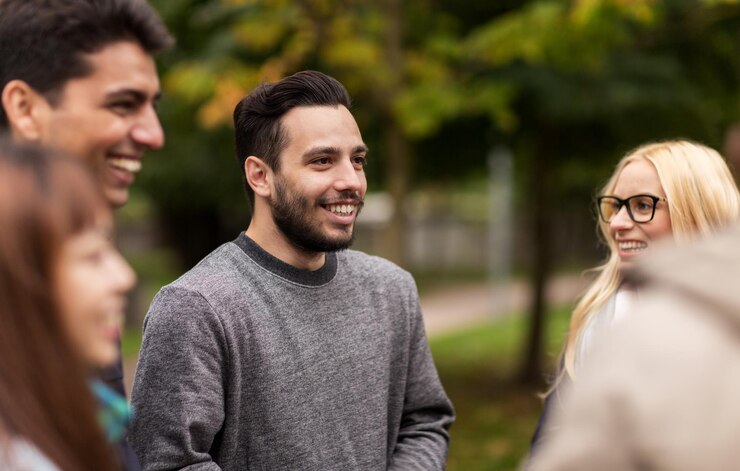 Foto menschen, freundschaft, kommunikation und internationales konzept - gruppe glücklicher freunde, die im herbstpark spazieren gehen