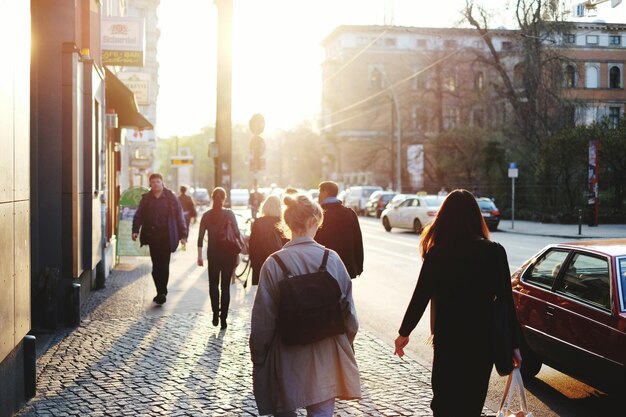 Menschen gehen auf dem Bürgersteig in der Stadt gegen die helle Sonne