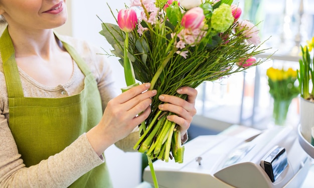 Menschen, Geschäft, Verkauf und Floristikkonzept - Nahaufnahme einer glücklichen Floristin, die im Blumenladen einen Haufen macht
