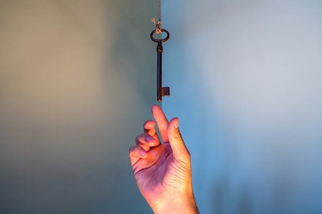 Menschen Hand greifen nach Vintage-Schlüssel hängen an einer Schnur.