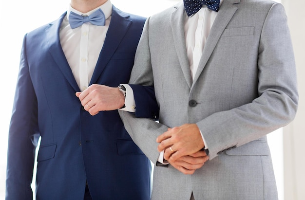 Menschen, Homosexualität, gleichgeschlechtliche Ehe und Liebeskonzept - Nahaufnahme eines glücklichen männlichen schwulen Paares, das bei der Hochzeit Händchen hält