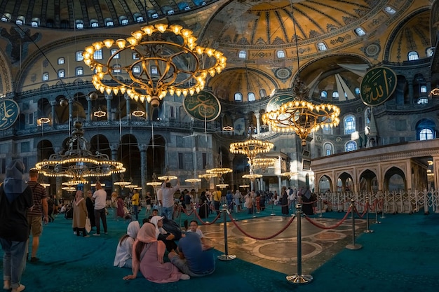 Menschen in der antiken byzantinischen Hagia Sophia Moschee mit Wandgemälden und großen Kronleuchtern Istanbul Turkiye
