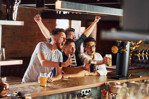 Menschen in Freizeitkleidung sitzen in der Kneipe und trinken Bier