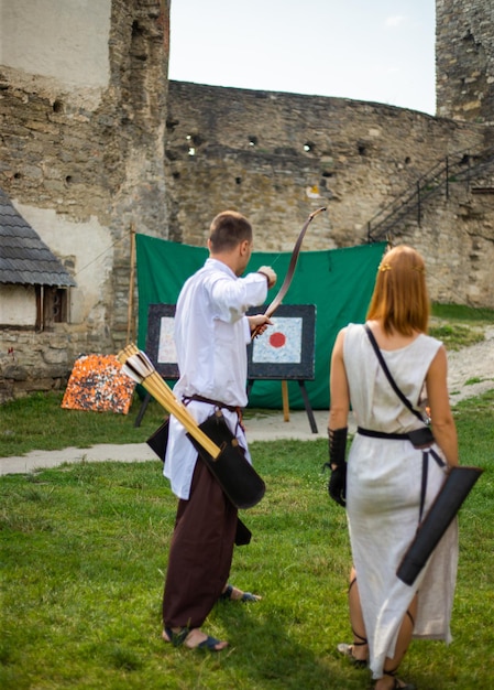 Menschen in mittelalterlicher Kleidung mit Schleifen auf dem Territorium der Burg