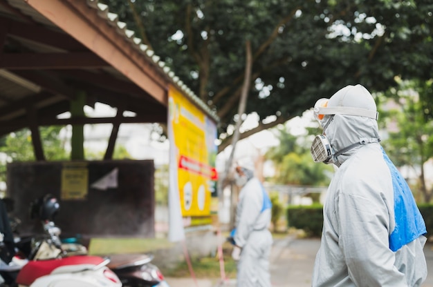 Menschen in weißem Schutzanzug, die die Straßen der Stadt reinigen und sterilisieren