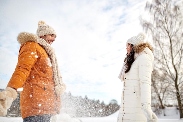 menschen, jahreszeit, liebe und freizeitkonzept - glückliches paar, das im winter mit schnee spielt