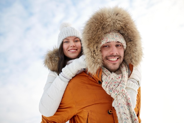 menschen, jahreszeit, liebe und freizeitkonzept - glückliches paar, das spaß über winterhintergrund hat